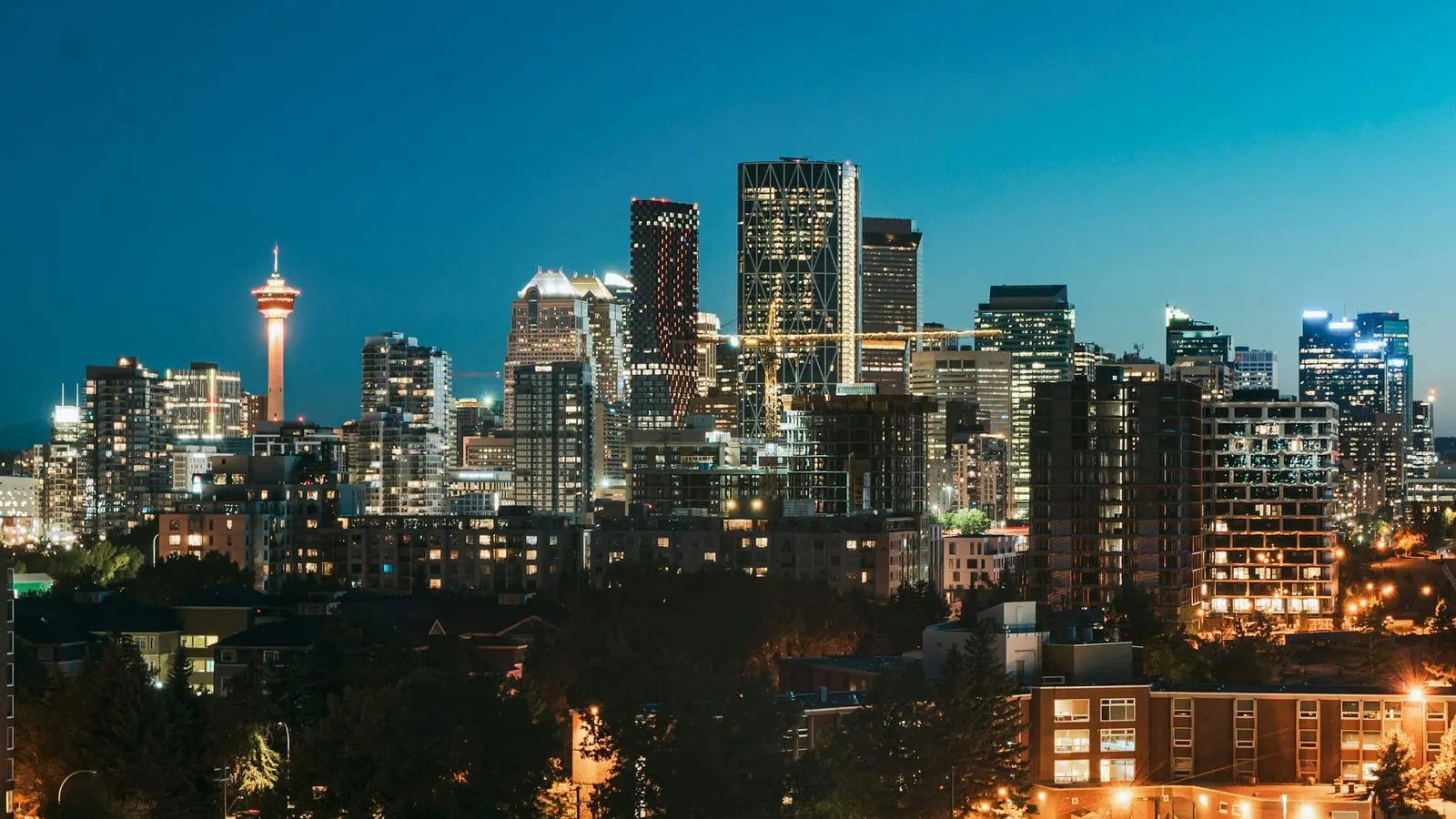 A Canadian city skyline at dusk with office towers lit from within.