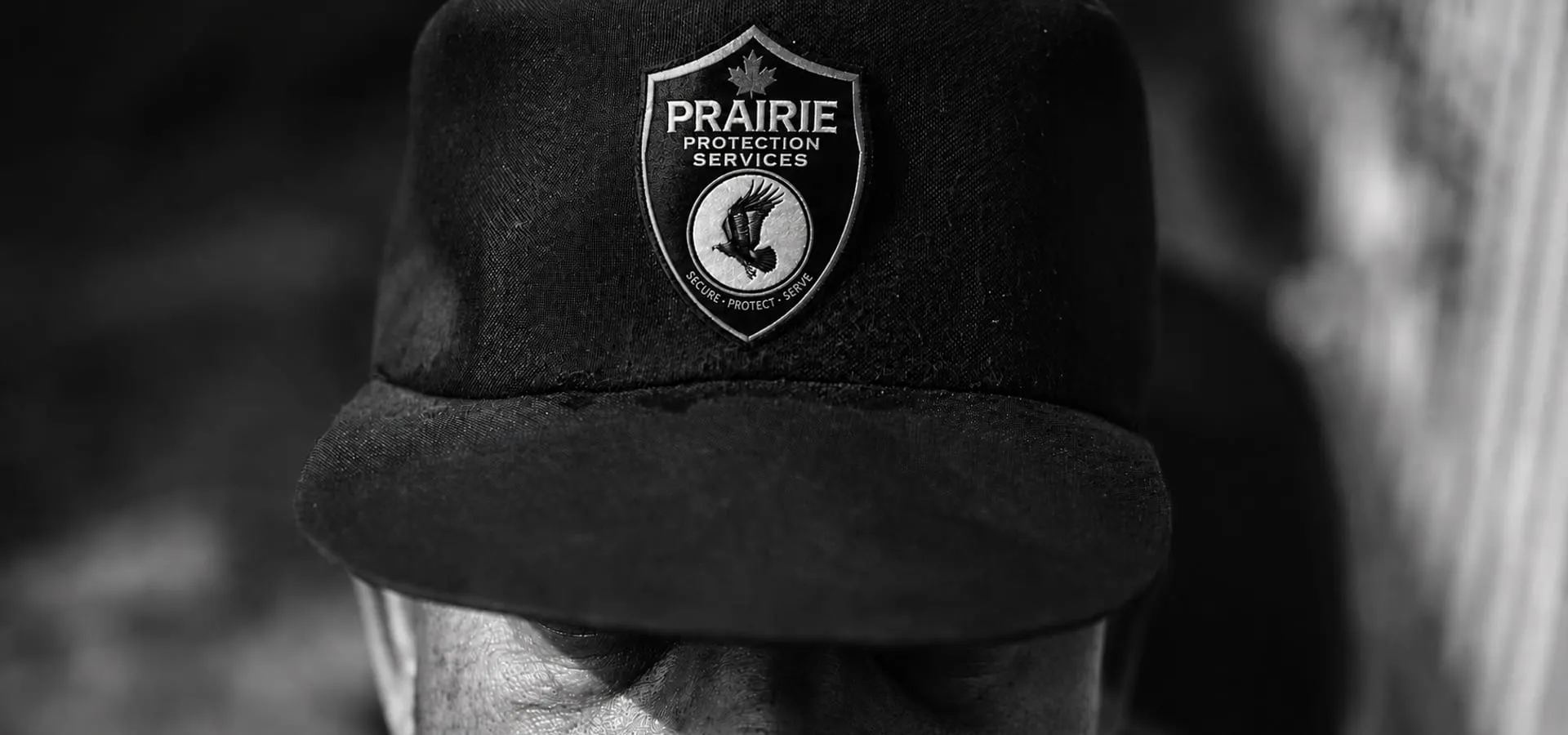 Close portrait of an officer wearing a cap badged with the Prairie Protection Services crest.
