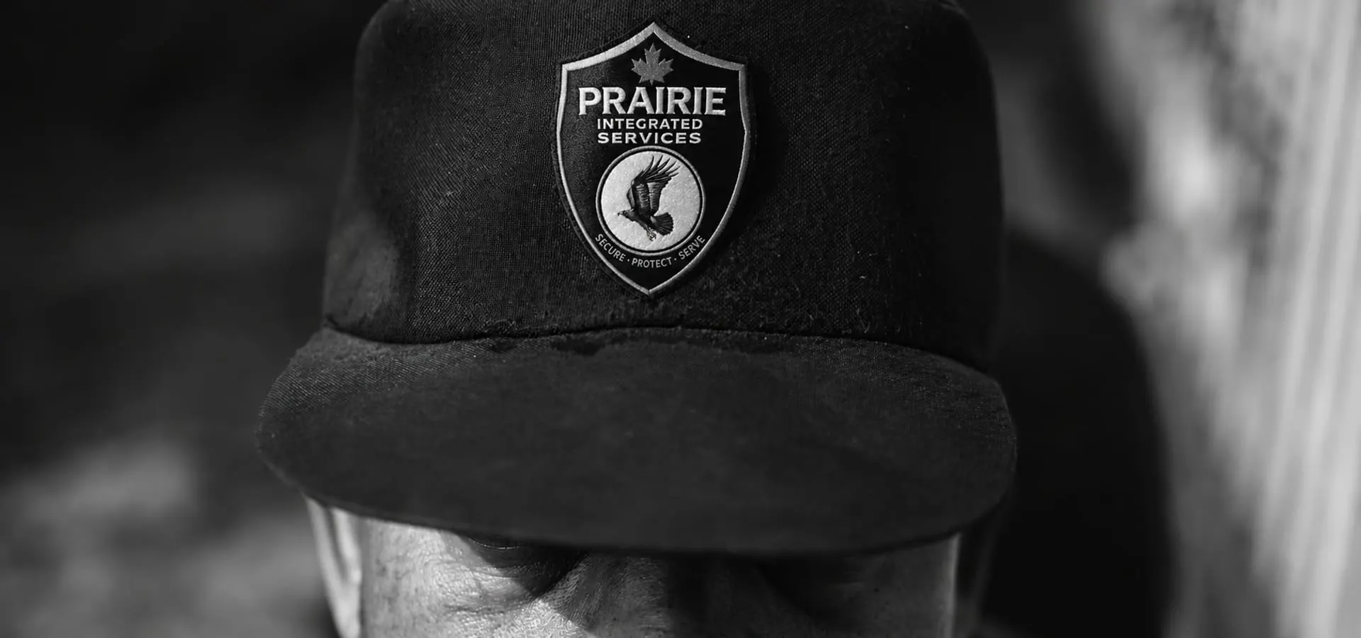 Close portrait of an officer wearing a cap badged with the Prairie Protection Services crest.